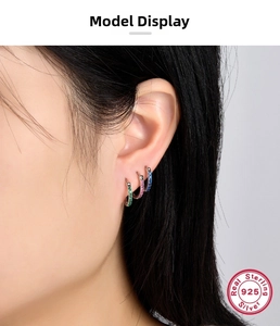 Macro shot of 925 sterling silver hoop earrings with vibrant colorful zircons on a model