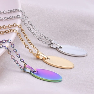 Macro shot of oval metal pendants in gold, silver, and rainbow colors on white silk fabric
