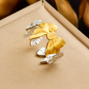 Detailed view of bicolor gold and silver bow ring with brushed metal texture on jewelry box