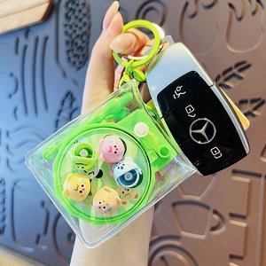 Green liquid water bag keychain featuring floating cartoon characters and swivel hook