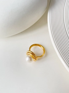 Vue détaillée d'une bague en acier titane doré avec perle blanche et design en spirale