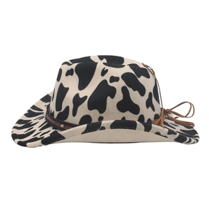 Cowboy felt hat with black and white cow spots and brown studded leather band