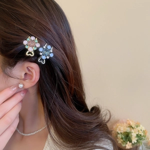 Gros plan de barrettes à fleurs élégantes avec strass colorés sur une base en cœur