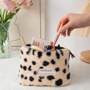 Plush leopard print makeup bag with Love Youth label shown in a lifestyle setting