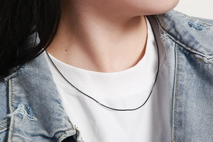 Close-up of a minimalist silver stainless steel snake chain necklace worn by a model