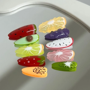 Set of nine cute resin fruit hair clips including lemon and watermelon on white surface