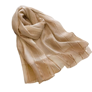 Elegant beige silk and wool scarf featuring shiny gold stripes on a clean white background