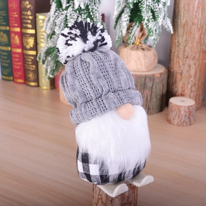 Christmas gnome doll with grey knit hat and plaid body on a cozy winter backdrop