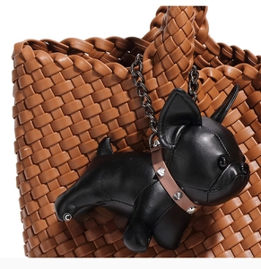 Close-up of black leather french bulldog bag charm on hand-woven tote bag handle