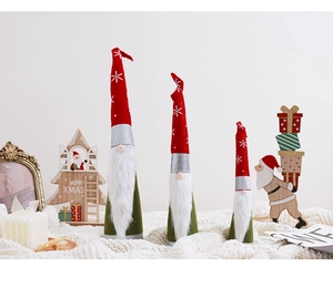 Three festive Christmas gnomes in red and green sequins on a cozy white knitted blanket