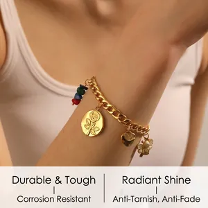 Gros plan d'un bracelet doré avec pendentifs rose, cœur, abeille et perles multicolores