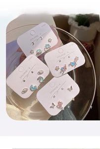 Close-up of S925 silver stud earring set with iridescent butterfly and celestial shapes