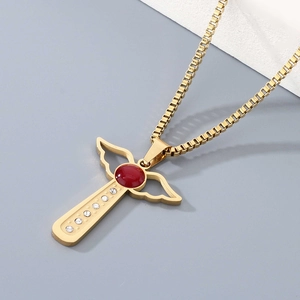 Detail of gold angel wing cross necklace with red gemstone and white zircon stones