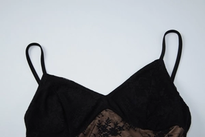 Detailed macro shot of elegant black floral lace with nude mesh lining on camisole dress