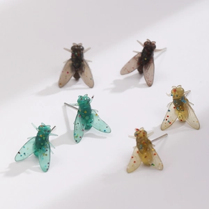 Orecchini a mosca realistici in resina con dettagli glitter su sfondo bianco