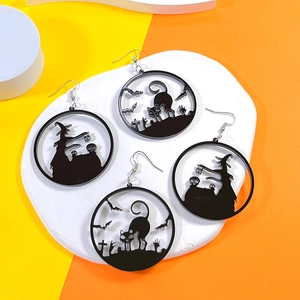 Macro view of Halloween acrylic earrings featuring black cat, bat, and witch silhouettes