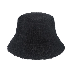 Close-up of thick black plush texture and soft faux fur material on a winter bucket hat