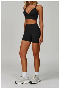 Detail of a black seamless yoga sports bra and high-waisted shorts on a model