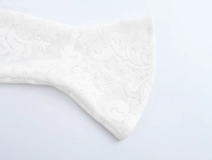 Detailed close-up of white floral lace fabric on dress sleeve cuff