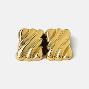 Chic geometric gold wavy textured metal earrings for women on a white background