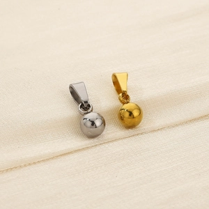 Polished silver and gold round ball pendant charms in minimalist stainless steel style