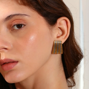 Boucles d'oreilles trapèze rayées bicolores en acier plaqué or 18 carats sur modèle