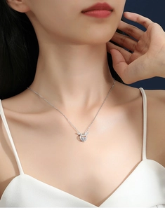 Close-up of elegant silver deer antler heart pendant with sparkling moissanite stone