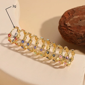 14K gold plated evil eye hoop earrings set with colorful enamel finish on stone display