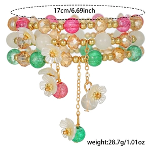 Détail du bracelet en perles multicouches avec cristaux colorés et breloques de fleurs