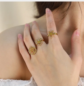 Three-piece gold adjustable ring set with tree of life, heart, and star designs on model