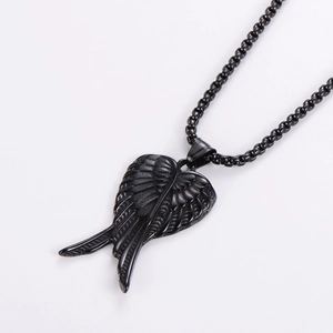 Détail d'un pendentif aile en métal noir de style punk rétro avec chaîne à perles