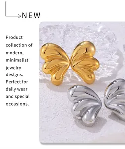 Macro shot of minimalist butterfly wing earrings in polished gold and silver finishes