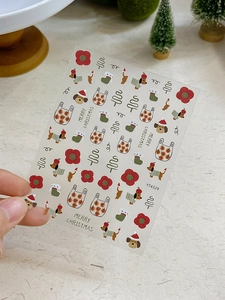 Close-up of 3D embossed Christmas nail stickers featuring puppies and festive socks