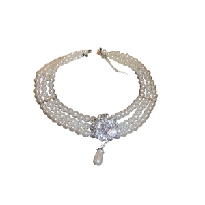 Elegant triple-layer pearl necklace with a sparkling diamond flower and teardrop pearl pendant