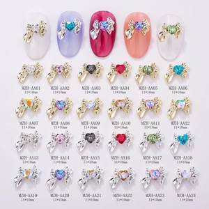 Dettaglio macro di fiocchi per nail art in lega con strass a cuore in vari colori brillanti