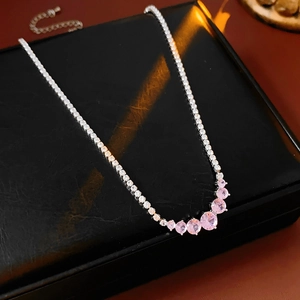 Close-up of elegant silver necklace with pink round gems on black leather box