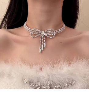 Dettaglio della collana choker con fiocco di strass scintillanti e nappe di perle