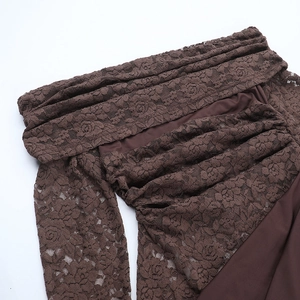 Dettaglio in pizzo marrone scuro con motivi floreali e pieghe eleganti sul vestito
