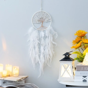 White tree of life dreamcatcher with natural feathers and beads hanging in cozy decor