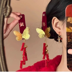 Detailed close-up of velvet butterfly hair clips with golden tassels and charms