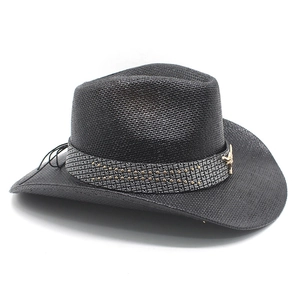 Detail of western black straw hat with silver rivets and golden bull head emblem