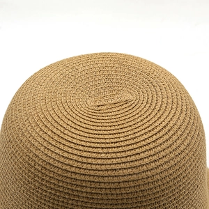 Vue détaillée du tissage en paille en spirale et texture du sommet d'un chapeau marron