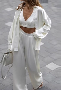 Détail de l'ensemble trois pièces en satin crème pour femme avec chemise, crop top et pantalon