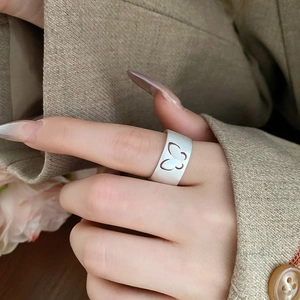 Detailed view of silver hollow butterfly ring on model wearing a khaki blazer