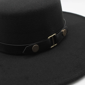 Detail of black wool fedora with faux leather band and gold metal buckle accents