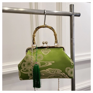 Detail der chinesischen Sticktasche mit Bambusgriff, grünem Satin und Seidenquaste