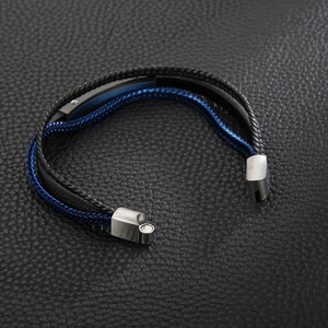Detail of multi-layer braided leather bracelet with blue metal plate and magnetic clasp