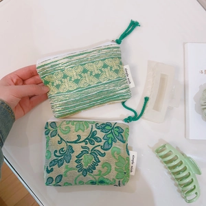 Detail of floral and geometric jacquard fabric pouches with zippers and hanging loops