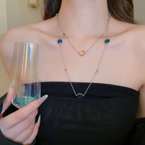 Detail of layered stainless steel necklace with colorful square crystal pendants