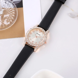 Dettaglio di un orologio al quarzo da donna con strass scintillanti e cinturino in pelle nera